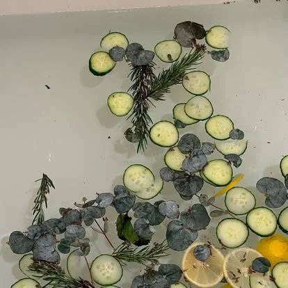 Cucumber, eucalyptus, rosemary and lemon floating in a bath