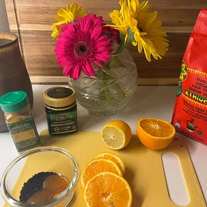 Gerbera daisies, oranges, lemon and honey on the counter