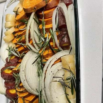 Sweet potato, onion and rosemary in a roasting dish
