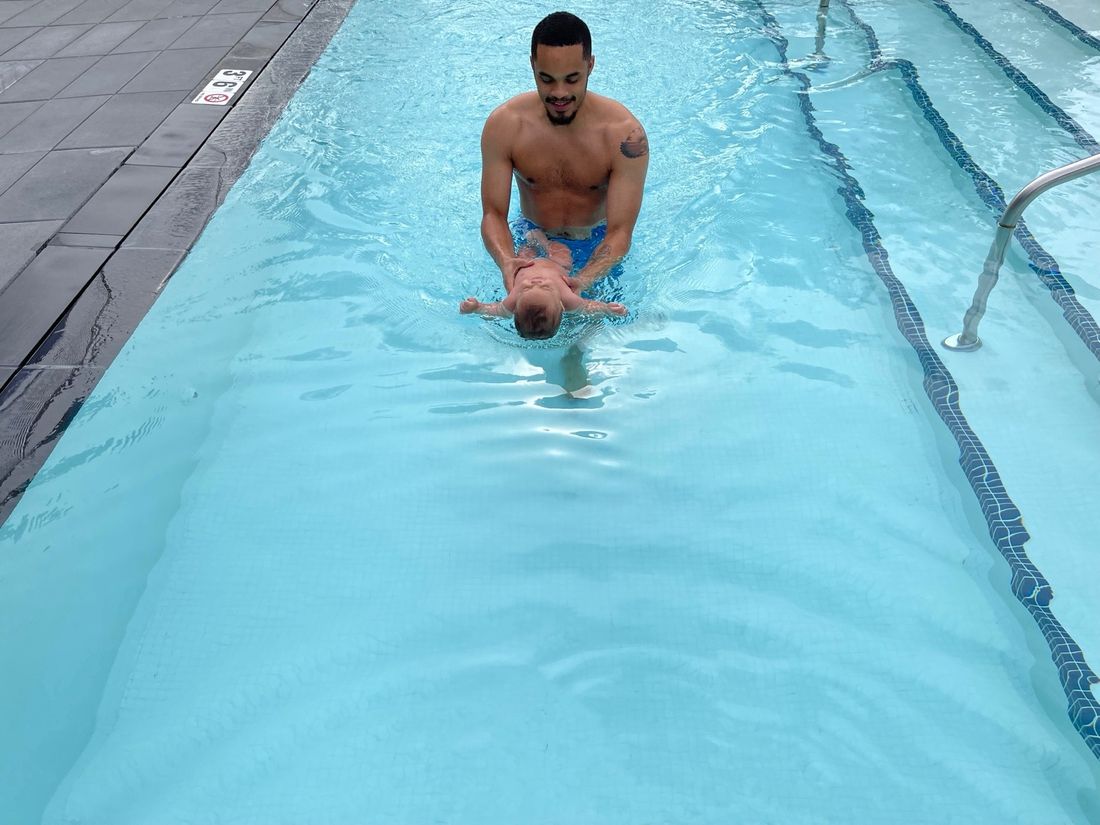 Coach Alexander teaching an infant to float on their back