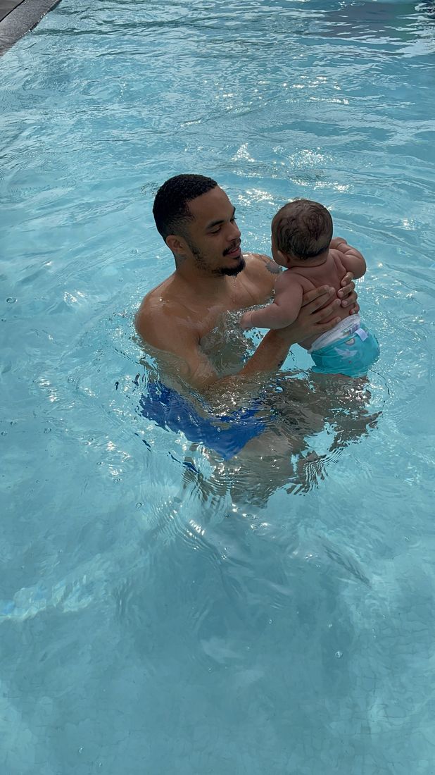 Coach Alexander holding an infant during a parent-and-tot lesson