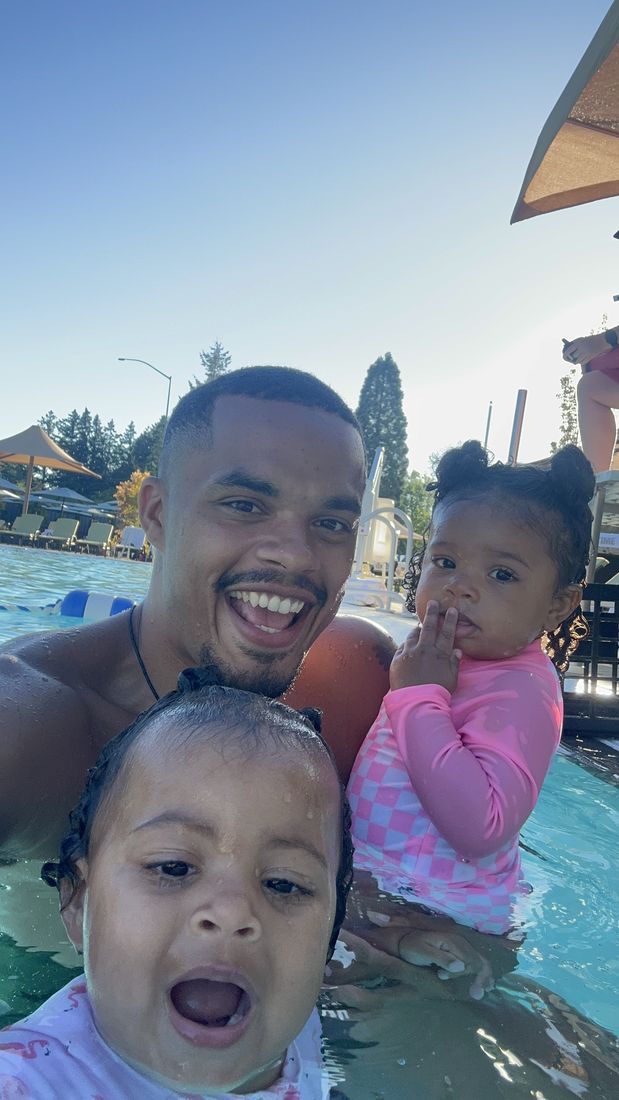 Coach Alexander with two little swimmers enjoying the pool